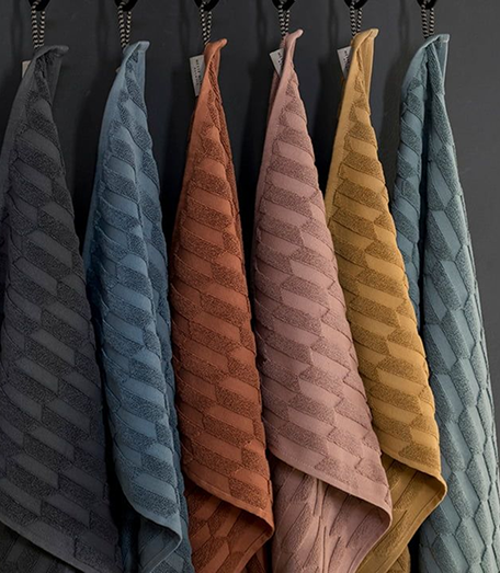A range of colored quilted towels hanging together